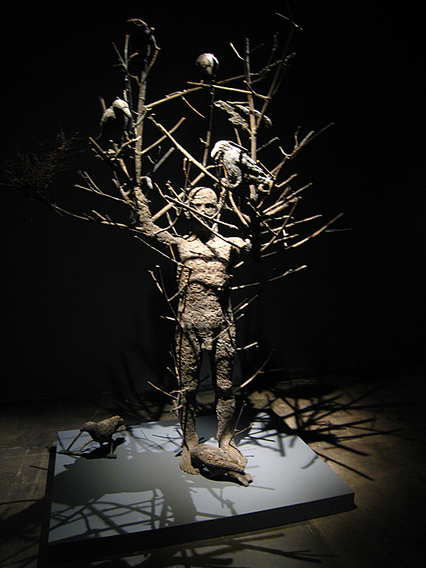 Man, as a tree, wth birds perched upon his limbs.