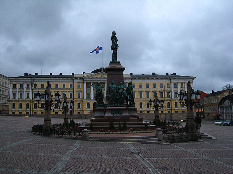 Some statues in the middle of the square, and the Finnish flag.